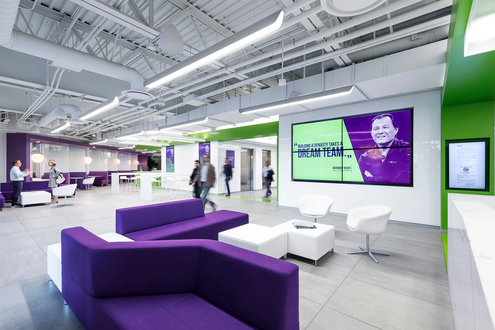 loanDepot workplace lounge with purple seating, green accents and a large wall display.
