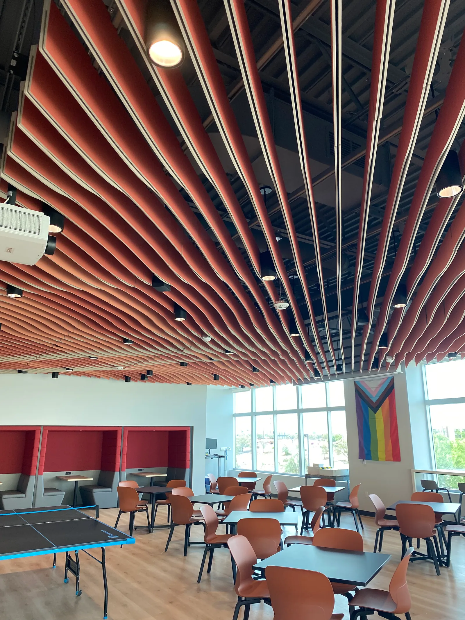 Shared lounge and café area with tables, windows and a table-tennis table.