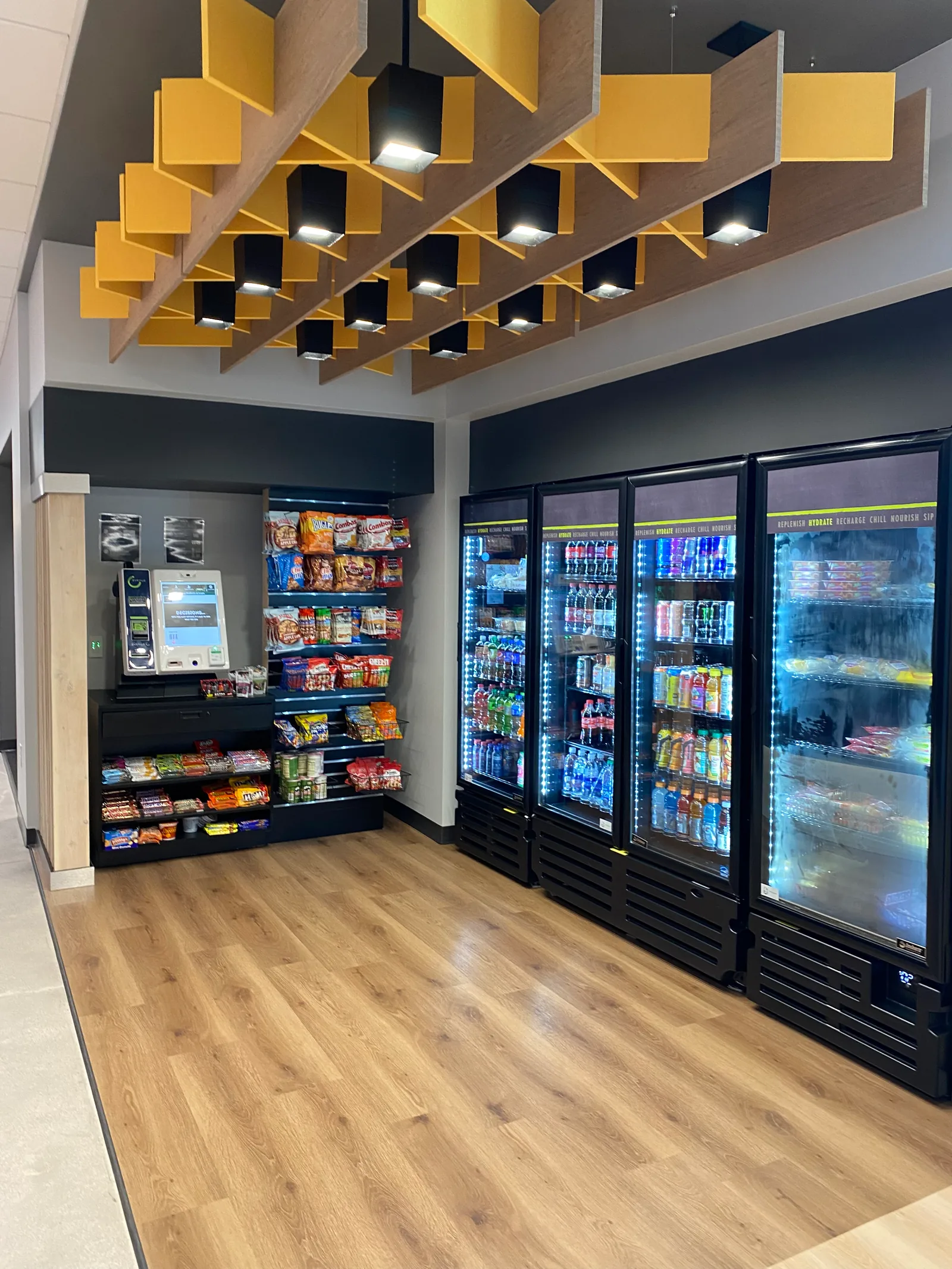 Refreshment area with snack shelving and refrigerated drinks.