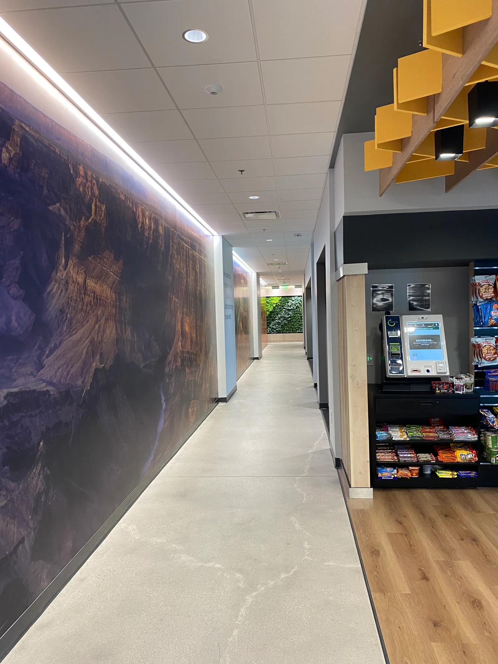 Corridor with a landscape wall graphic beside the refreshment area.