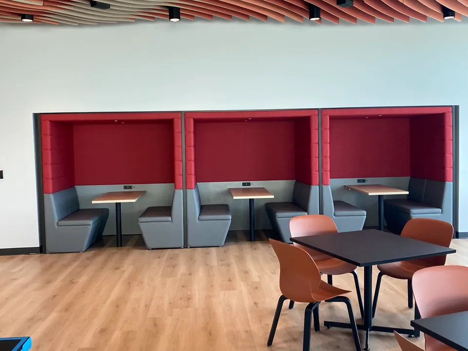 Café seating with red upholstered booths and a timber-slat ceiling.
