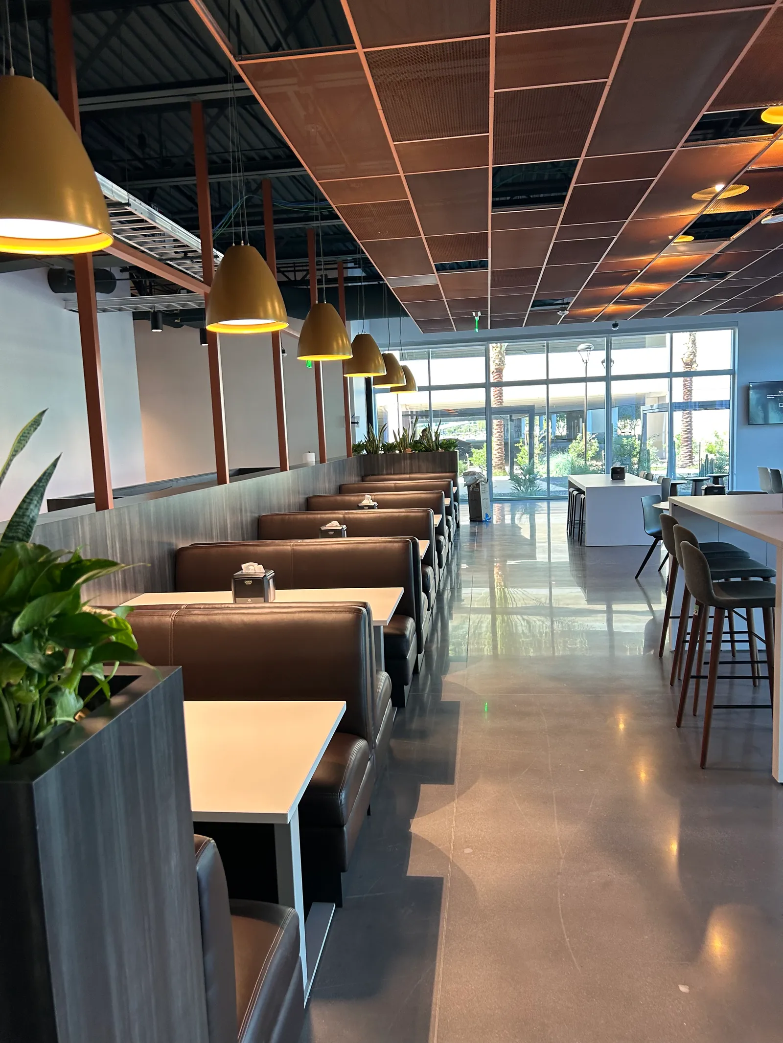 Shared café with booth seating, pendant lights and a central aisle.