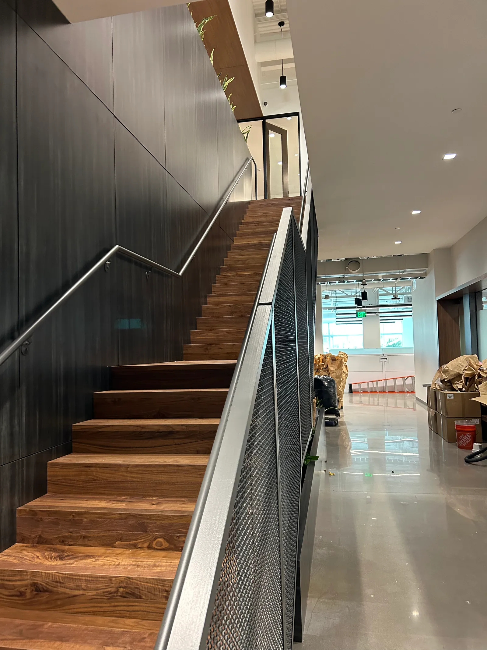 Timber staircase with dark metal handrails.