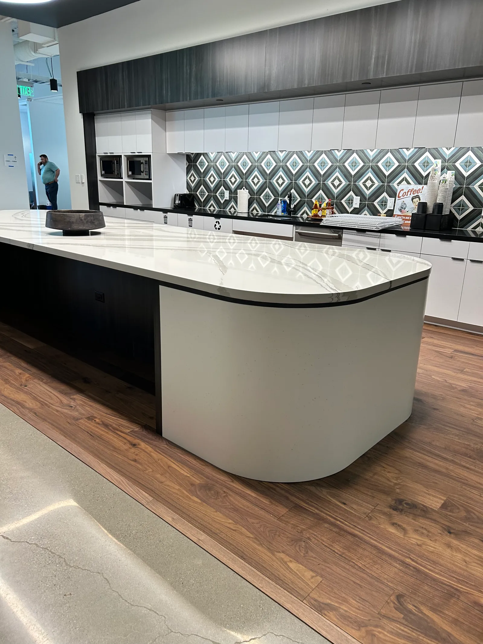 Kitchen island with curved ends and a patterned tile backsplash.