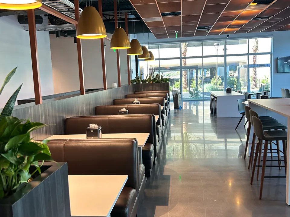 Shared café with booth seating, pendant lights and a central aisle.