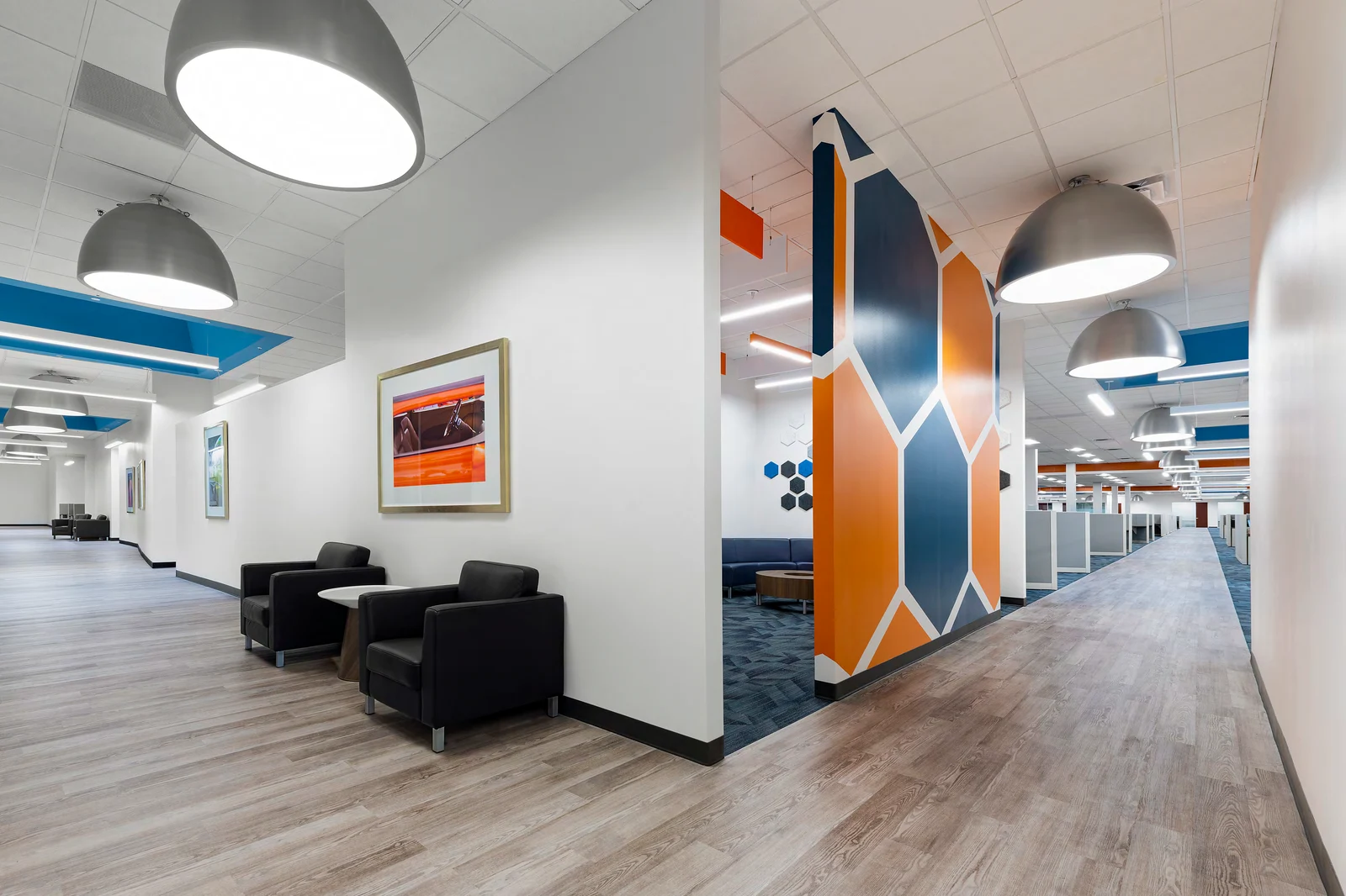 Open workplace with a blue and orange feature wall and shared lounge seating.