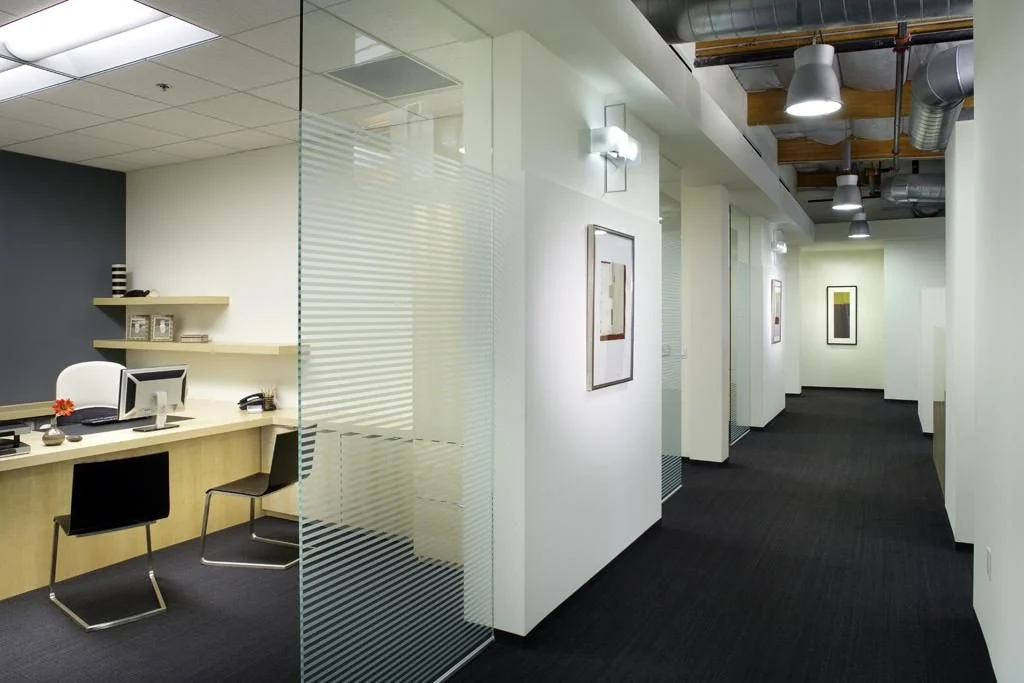 Glass-walled private office beside an interior corridor.