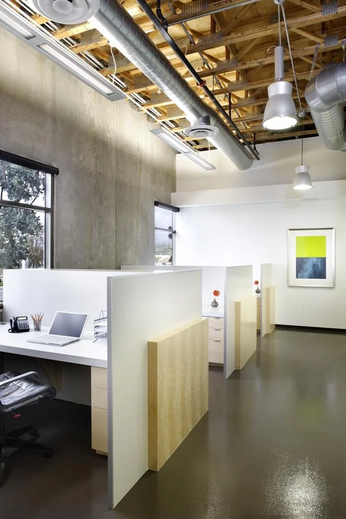 Workstations beneath a timber-accented ceiling.