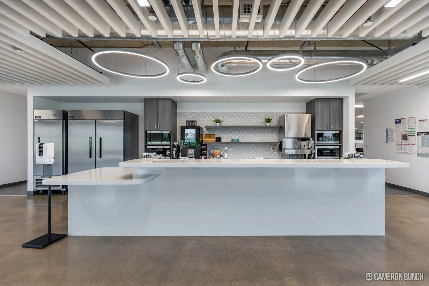 White café counter beneath ring-shaped pendant lights.