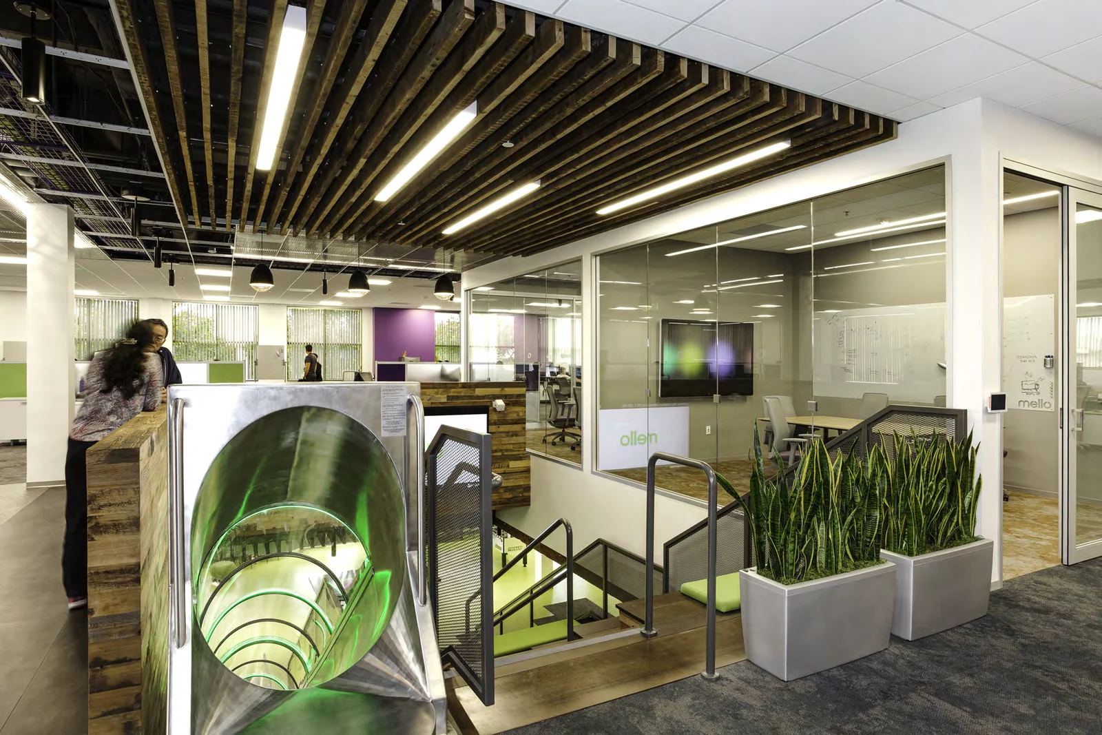 Upper-floor meeting area beside the staircase and slide.