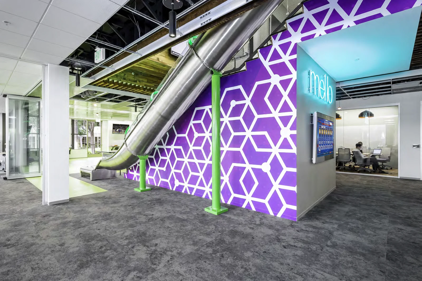 Purple brand wall beneath the stair and slide.