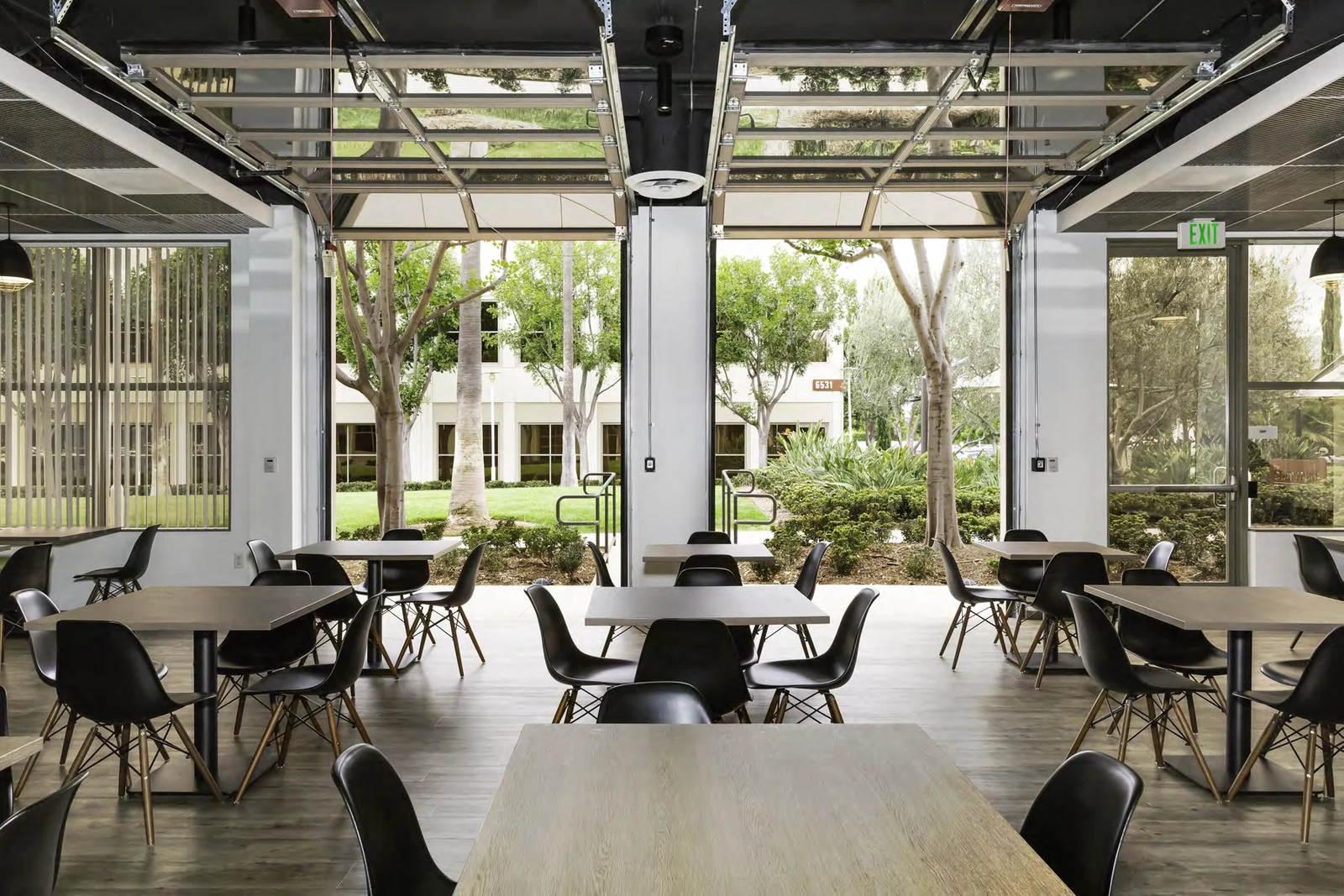 Café seating beside wide openings to the outdoors.