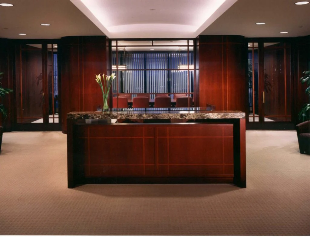 Reception with dark timber walls and a stone counter.