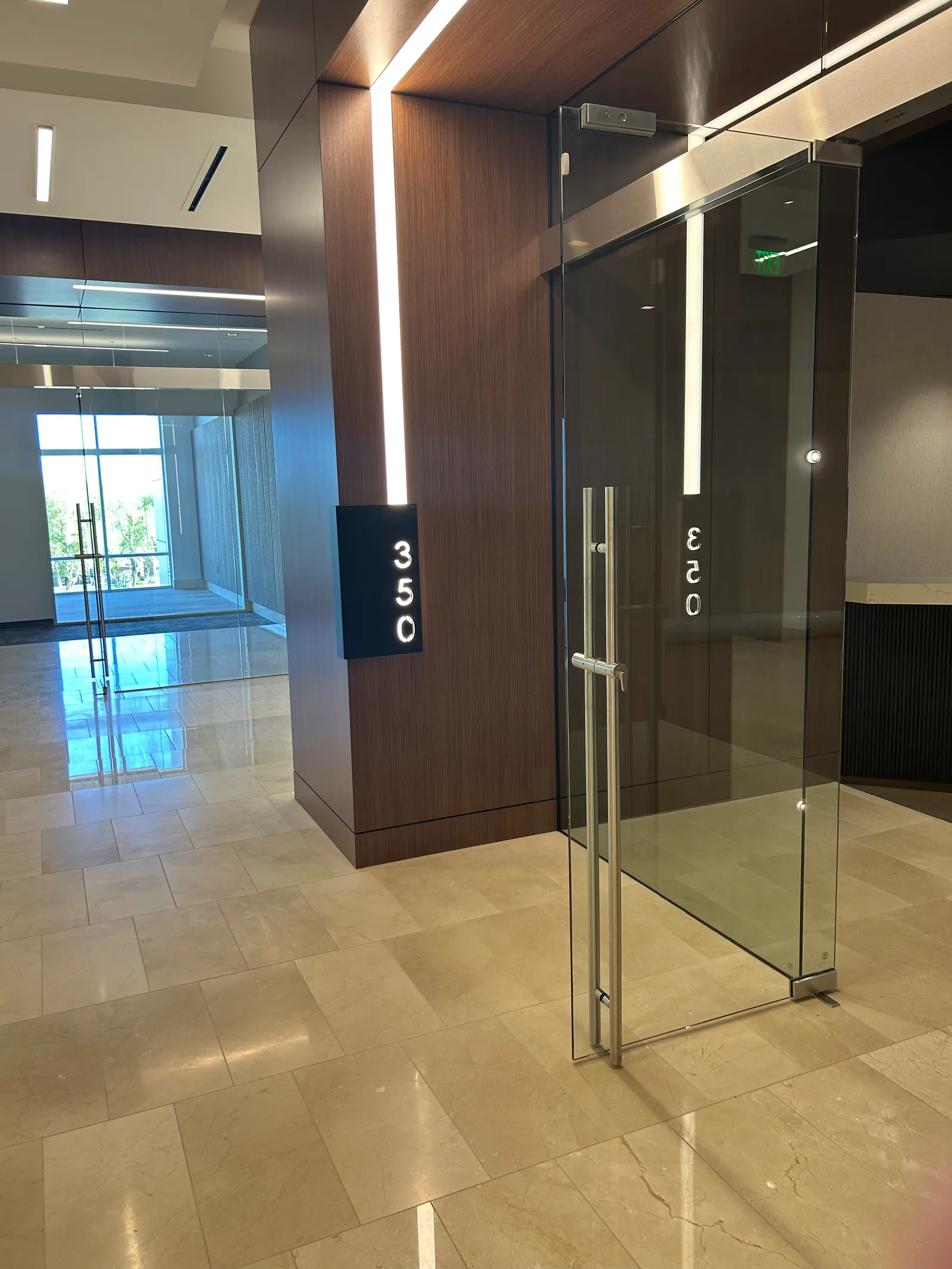 Glass entrance beside timber wall cladding.