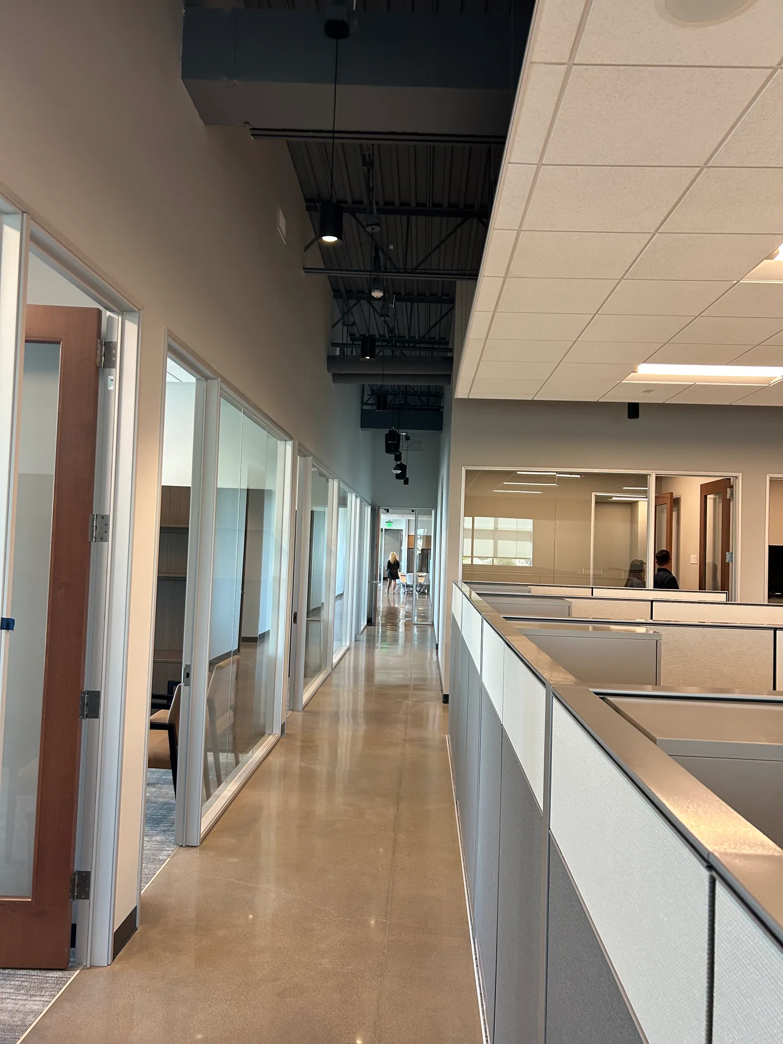 Open workstations beside a corridor and enclosed rooms.