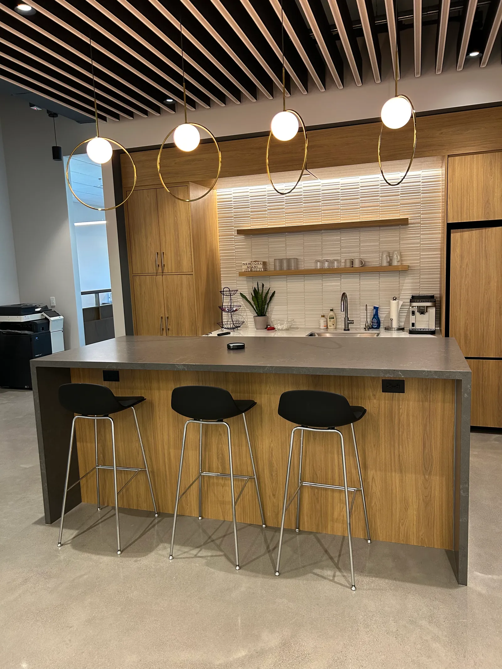 Shared kitchen with a timber-fronted island and bar stools.